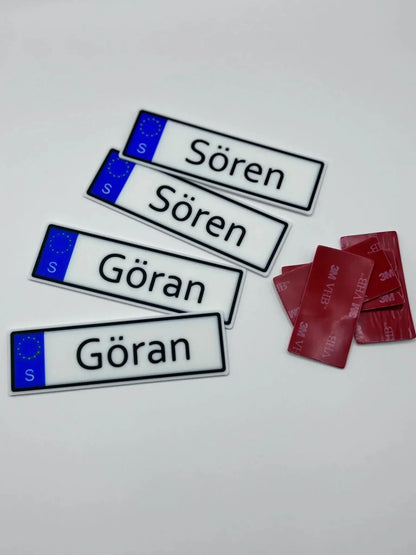 Personlig skylt till robotgräsklippare visad bredvid roboten